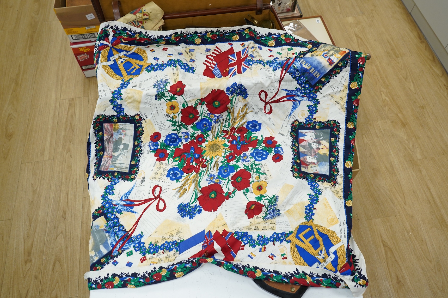 A suitcase of military related items, including; a Manchester Guardian issued early 20th century map of Europe printed on cotton, a First World War trench art match holder the base formed from a cartridge case, two swagg